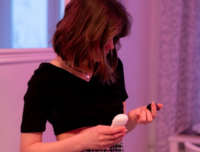 woman in a black top holding a deodorant
