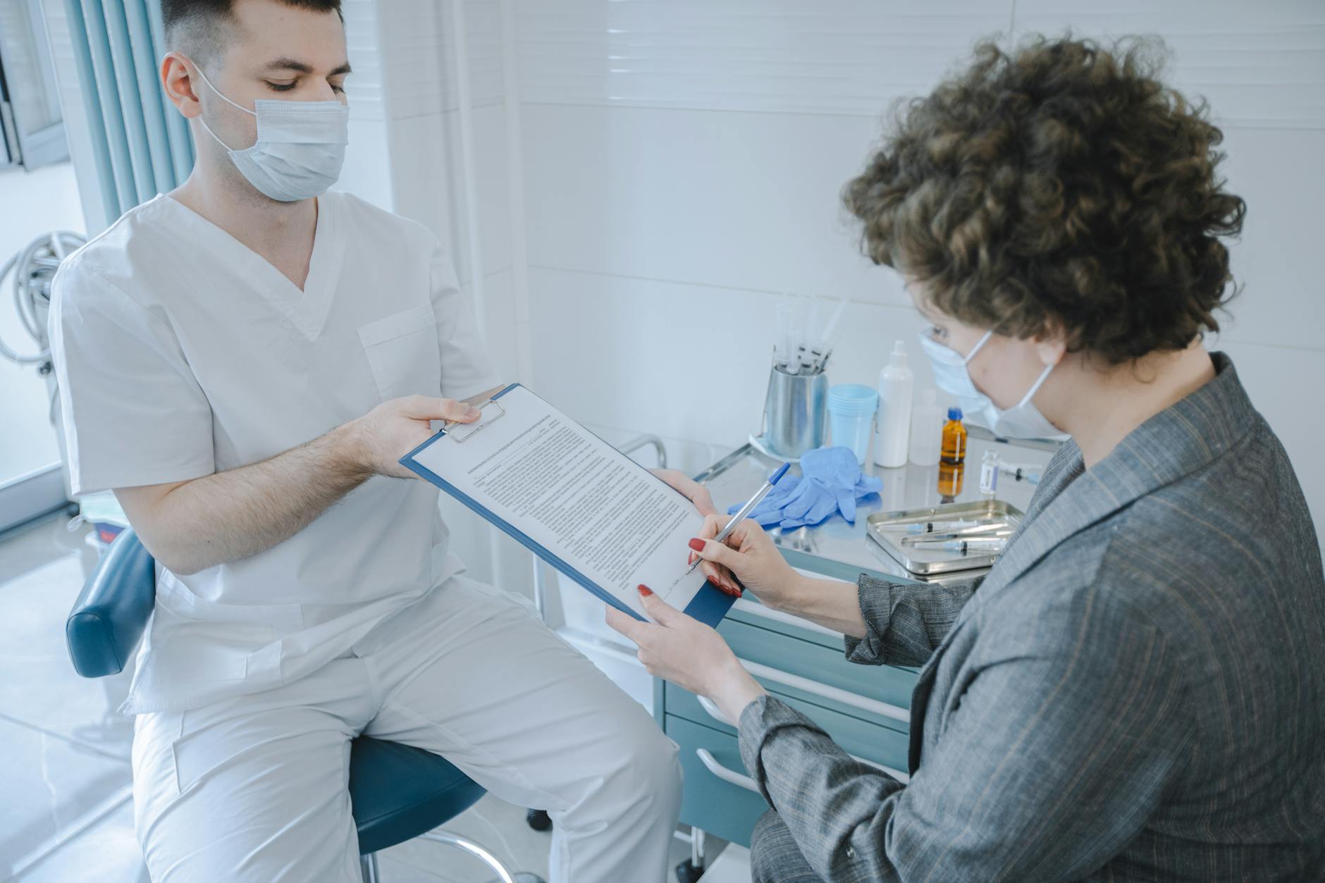 patient writing her signature on a document